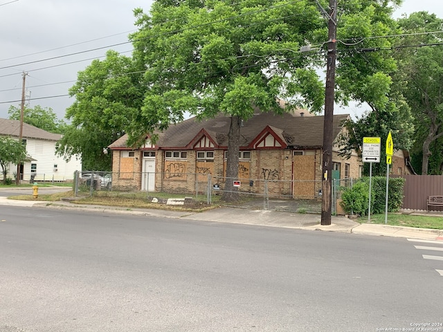 tudor home with a gate, fence private yard, and brick siding