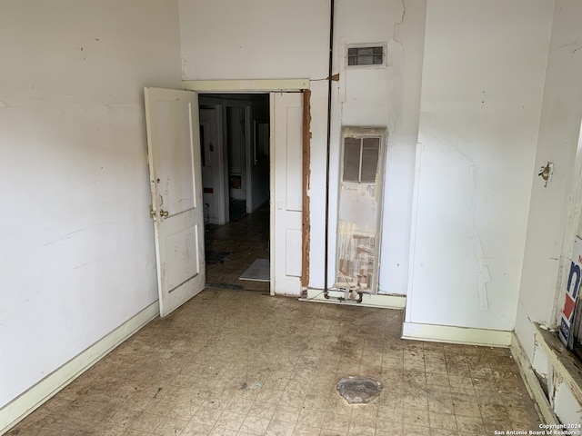 spare room featuring baseboards, a heating unit, tile patterned floors, and visible vents
