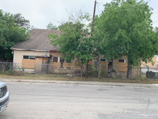view of property hidden behind natural elements with a fenced front yard