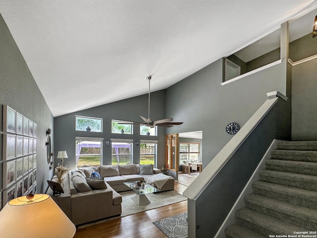 living area featuring wood finished floors, ceiling fan, lofted ceiling, and a healthy amount of sunlight