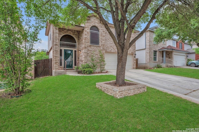 traditional-style house featuring brick siding, fence, a front yard, and concrete driveway