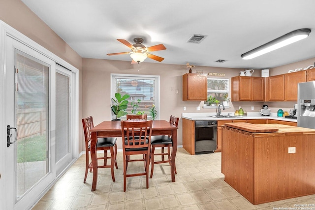 kitchen with light countertops, light floors, a ceiling fan, and black dishwasher
