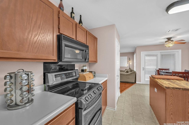 kitchen featuring ceiling fan, brown cabinetry, double oven range, visible vents, and black microwave