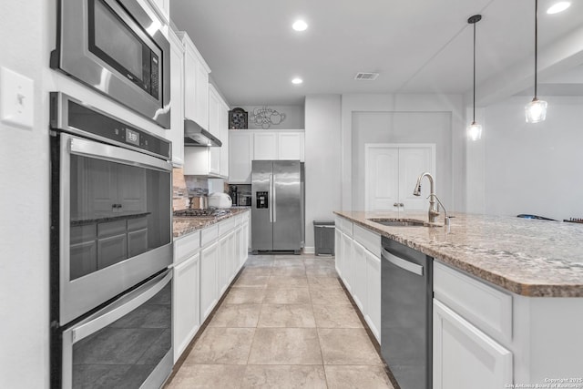 kitchen with wall chimney range hood, a sink, stainless steel appliances, recessed lighting, and white cabinetry