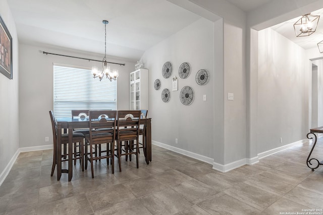 dining space with baseboards and a chandelier
