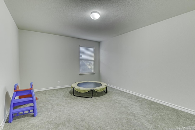 game room with baseboards, carpet, and a textured ceiling