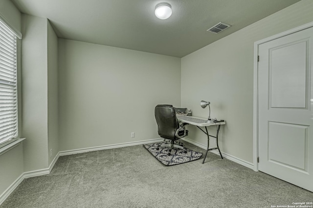 carpeted office space featuring visible vents and baseboards