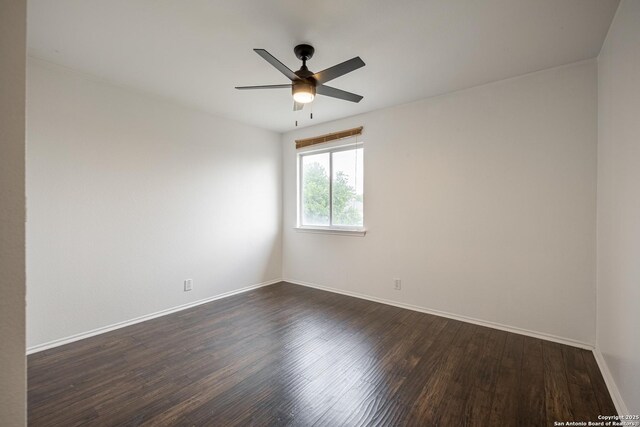 empty room featuring dark wood-style flooring, baseboards, and a ceiling fan