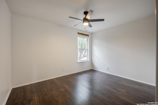 empty room with baseboards, ceiling fan, and dark wood-type flooring