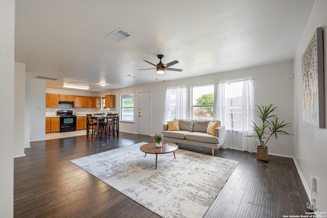 living area with visible vents, dark wood finished floors, ceiling fan, and baseboards