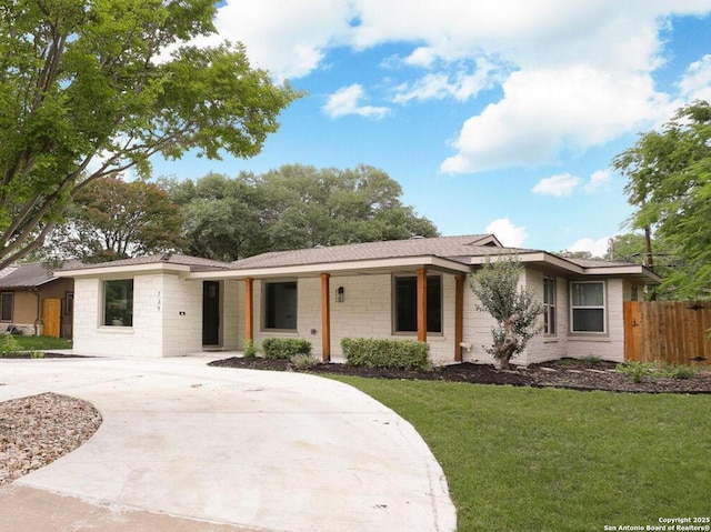 ranch-style house with fence, driveway, and a front yard