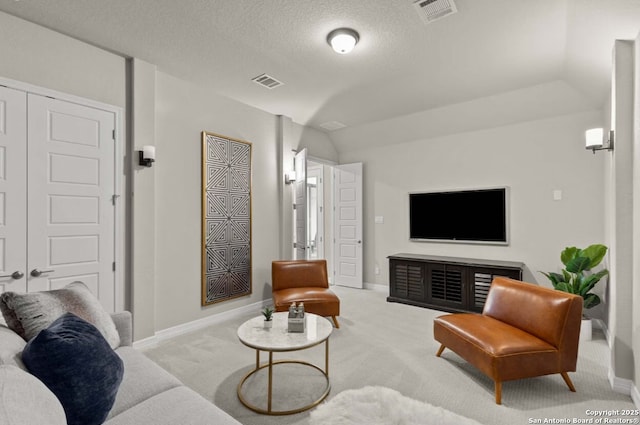 living room with carpet floors, a textured ceiling, visible vents, and baseboards