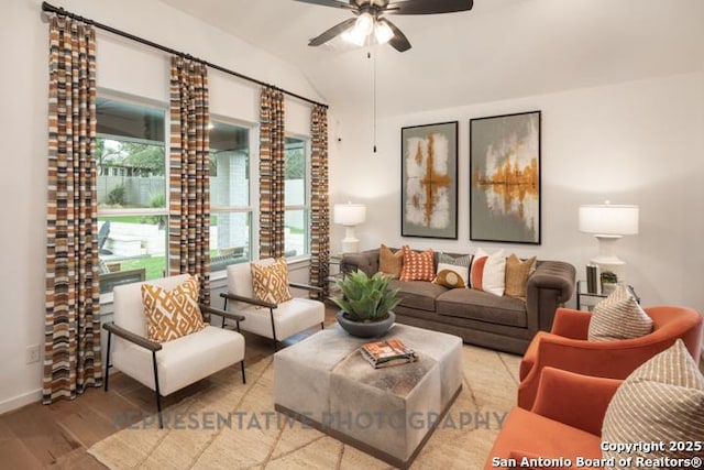 living area featuring baseboards, ceiling fan, wood finished floors, and lofted ceiling