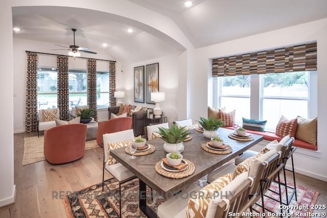 dining room with light wood-style floors, a ceiling fan, vaulted ceiling, and a wealth of natural light