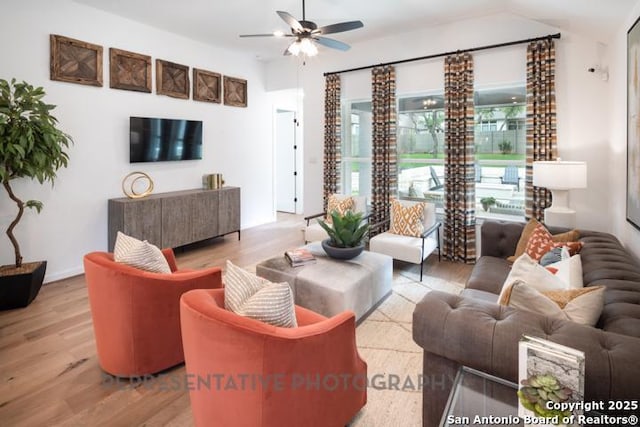living area featuring a ceiling fan and light wood-style flooring