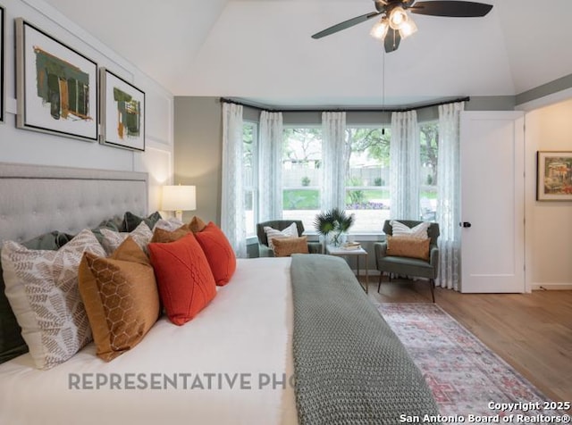 bedroom with ceiling fan, vaulted ceiling, and wood finished floors