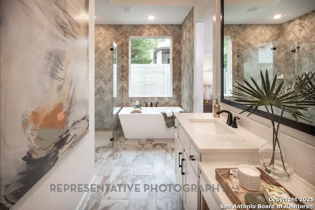 bathroom with vanity, marble finish floor, a freestanding tub, and a shower stall
