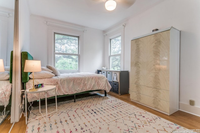 bedroom with crown molding and wood finished floors