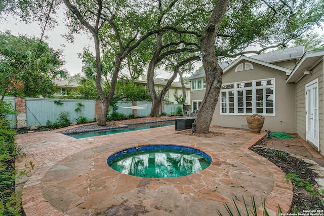 view of pool featuring french doors, a patio, an in ground hot tub, and a fenced backyard