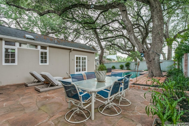 view of patio with a fenced in pool, french doors, a fenced backyard, and outdoor dining space