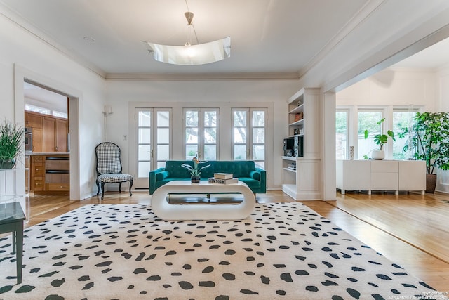 living area featuring light wood-style floors and ornamental molding