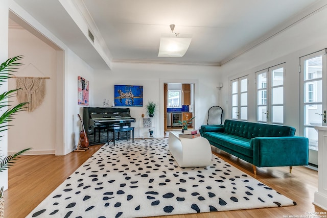 living room featuring beverage cooler, visible vents, a wealth of natural light, and wood finished floors