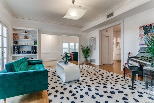 sitting room with ornamental molding, wood finished floors, and visible vents
