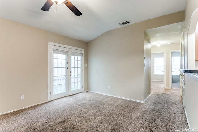 unfurnished room featuring carpet flooring, a ceiling fan, visible vents, and plenty of natural light