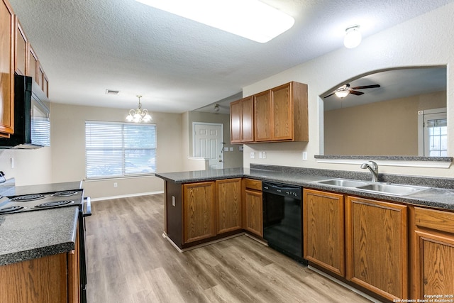 kitchen with brown cabinetry, a sink, black appliances, and light wood finished floors