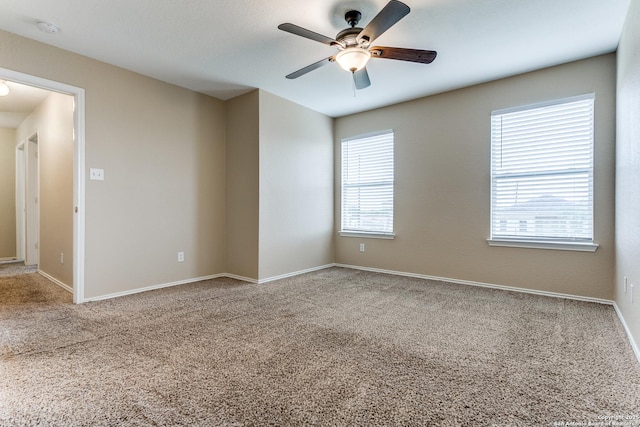 empty room featuring carpet floors, baseboards, and a ceiling fan
