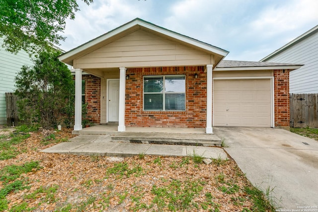 ranch-style home with brick siding, an attached garage, driveway, and a porch
