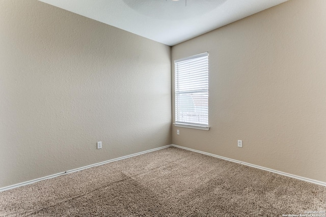 carpeted spare room featuring baseboards