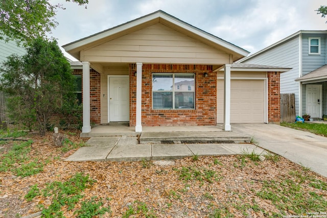 ranch-style home with brick siding, a garage, a porch, and concrete driveway