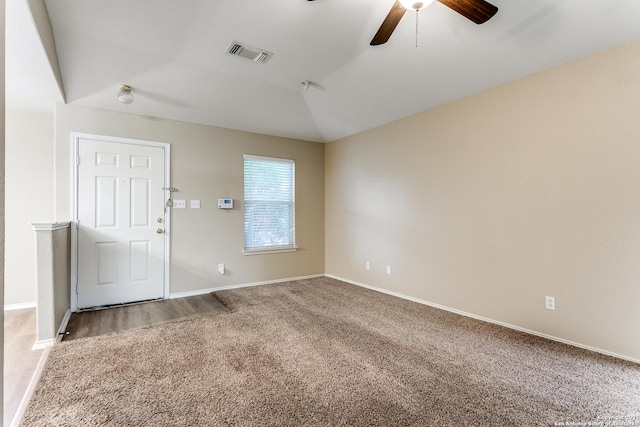 carpeted spare room featuring visible vents, baseboards, ceiling fan, and lofted ceiling