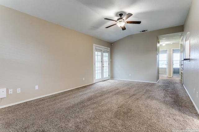 unfurnished room with a wealth of natural light, ceiling fan, carpet floors, and visible vents