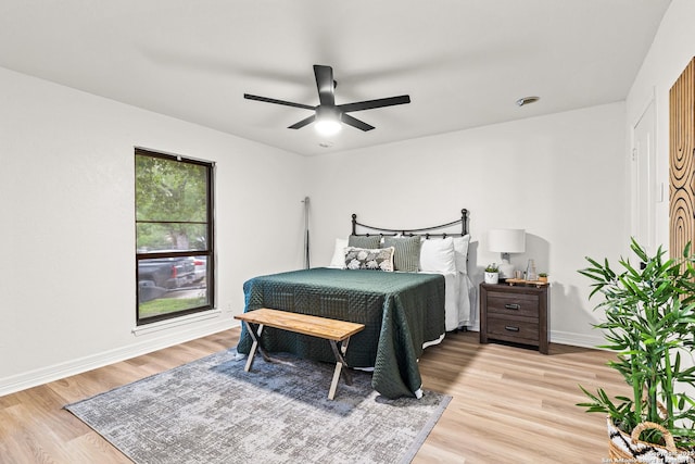 bedroom featuring baseboards, ceiling fan, and light wood finished floors