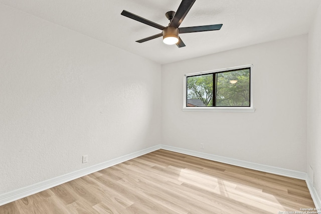 spare room featuring light wood-style floors, baseboards, and ceiling fan