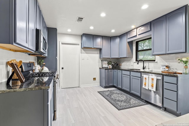 kitchen featuring visible vents, recessed lighting, dark stone counters, a sink, and appliances with stainless steel finishes