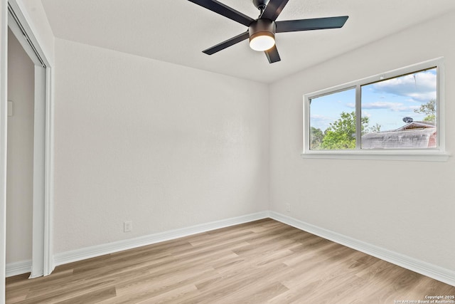 unfurnished room with baseboards, ceiling fan, and light wood-style flooring