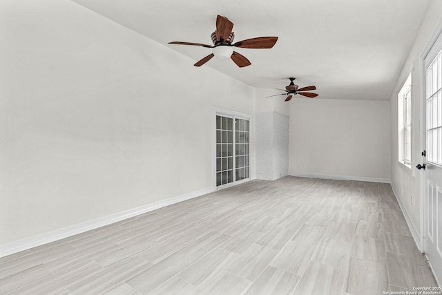 unfurnished room with ceiling fan, baseboards, and light wood-type flooring