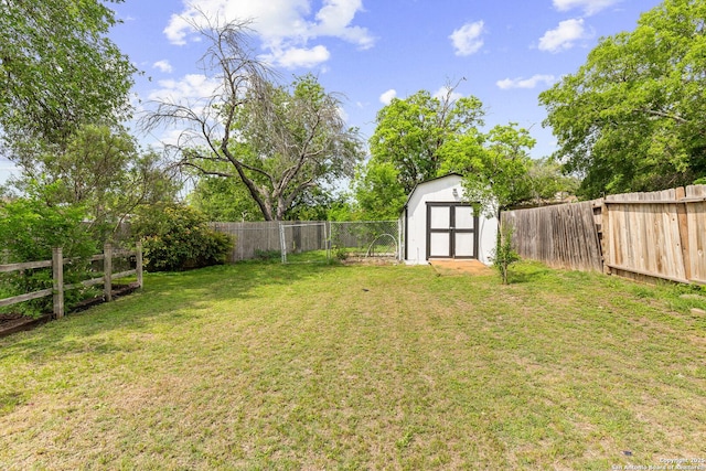 view of yard featuring an outdoor structure, a shed, and a fenced backyard