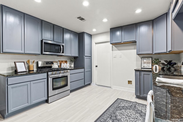 kitchen with visible vents, baseboards, dark stone counters, stainless steel appliances, and recessed lighting