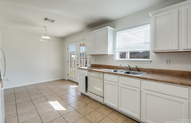kitchen featuring visible vents, white dishwasher, a sink, white cabinets, and light tile patterned flooring