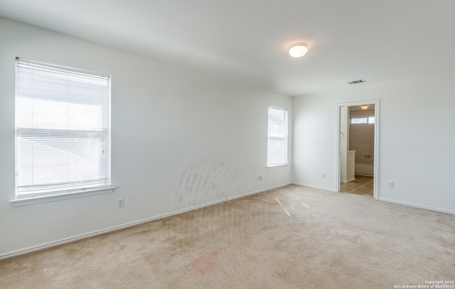 carpeted spare room with baseboards and visible vents