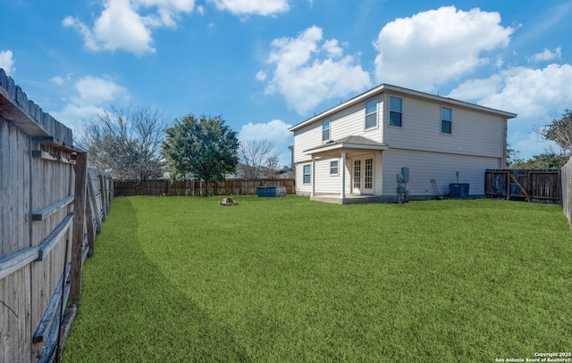 rear view of property featuring an outdoor fire pit, a fenced backyard, cooling unit, a patio, and a yard