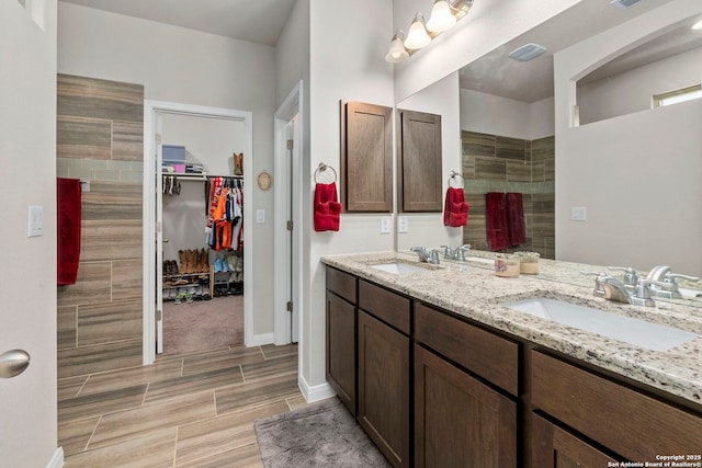 7914 Blackhawk Pass, San Antonio, TX 78253 - bathroom featuring double vanity, a spacious closet, and wood finish floors