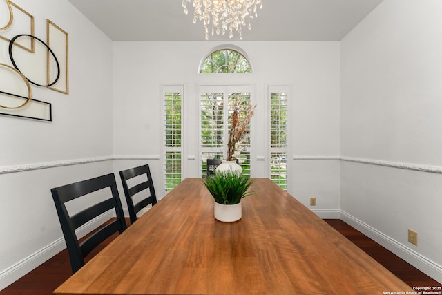 dining room featuring baseboards, dark wood-style flooring, and a notable chandelier