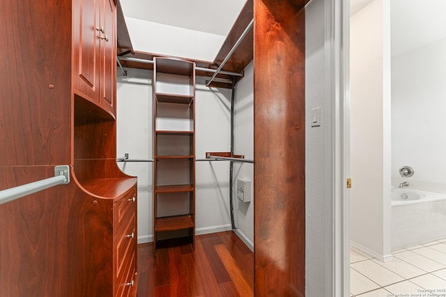 walk in closet with wood finished floors