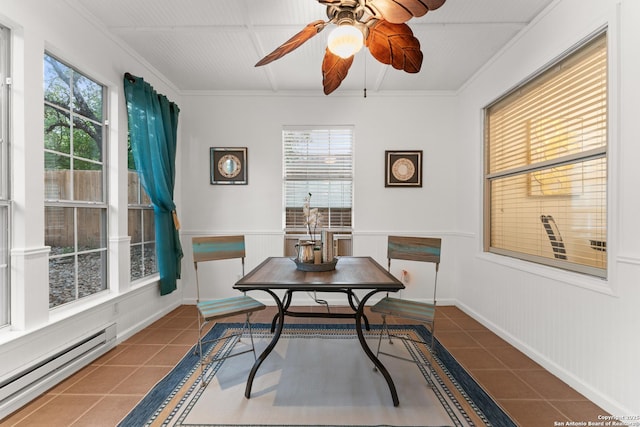tiled dining room with ceiling fan, a baseboard heating unit, ornamental molding, and a healthy amount of sunlight