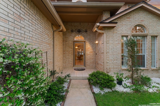entrance to property featuring brick siding